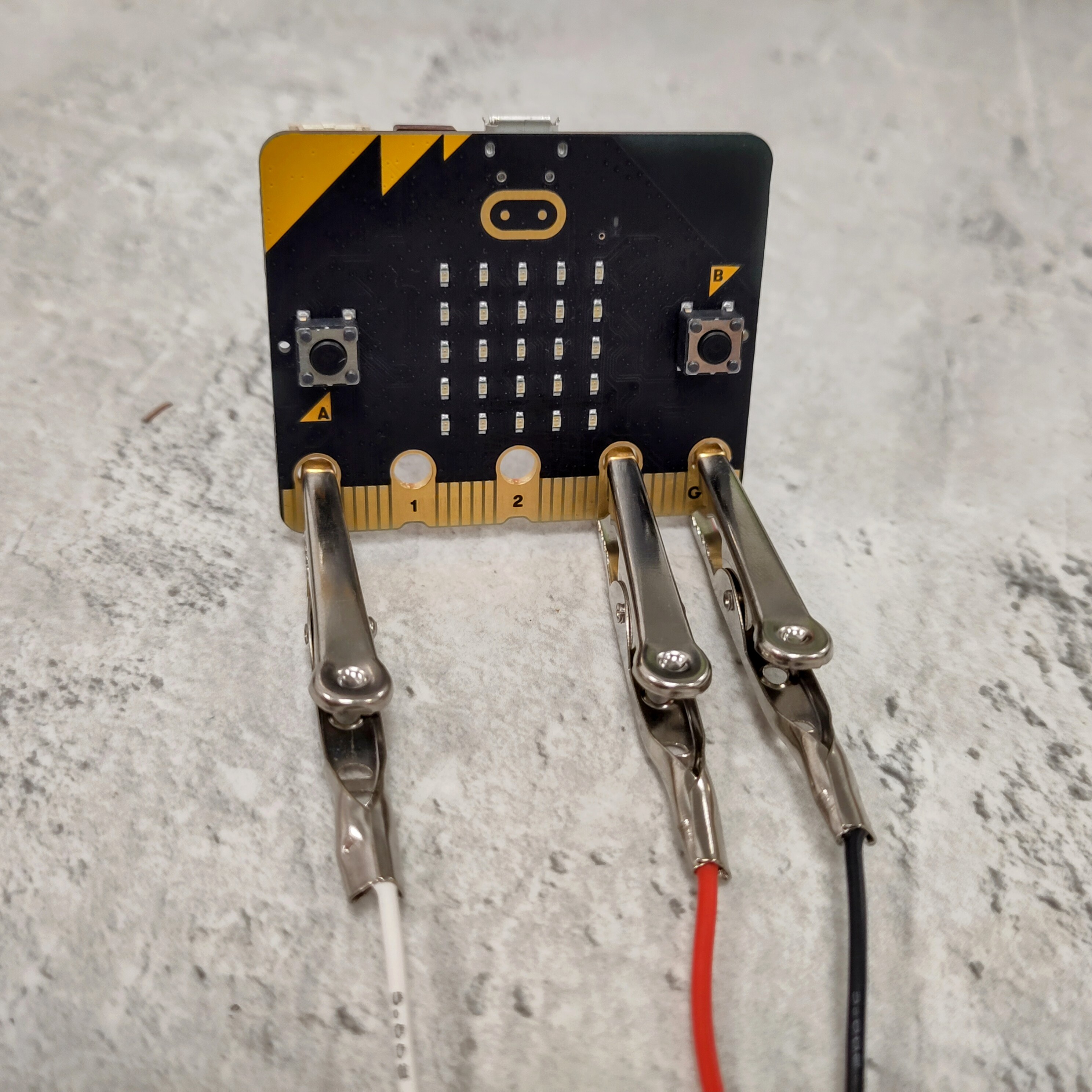 a close-up showing crocodile clips attached to the micro:bit, as described above